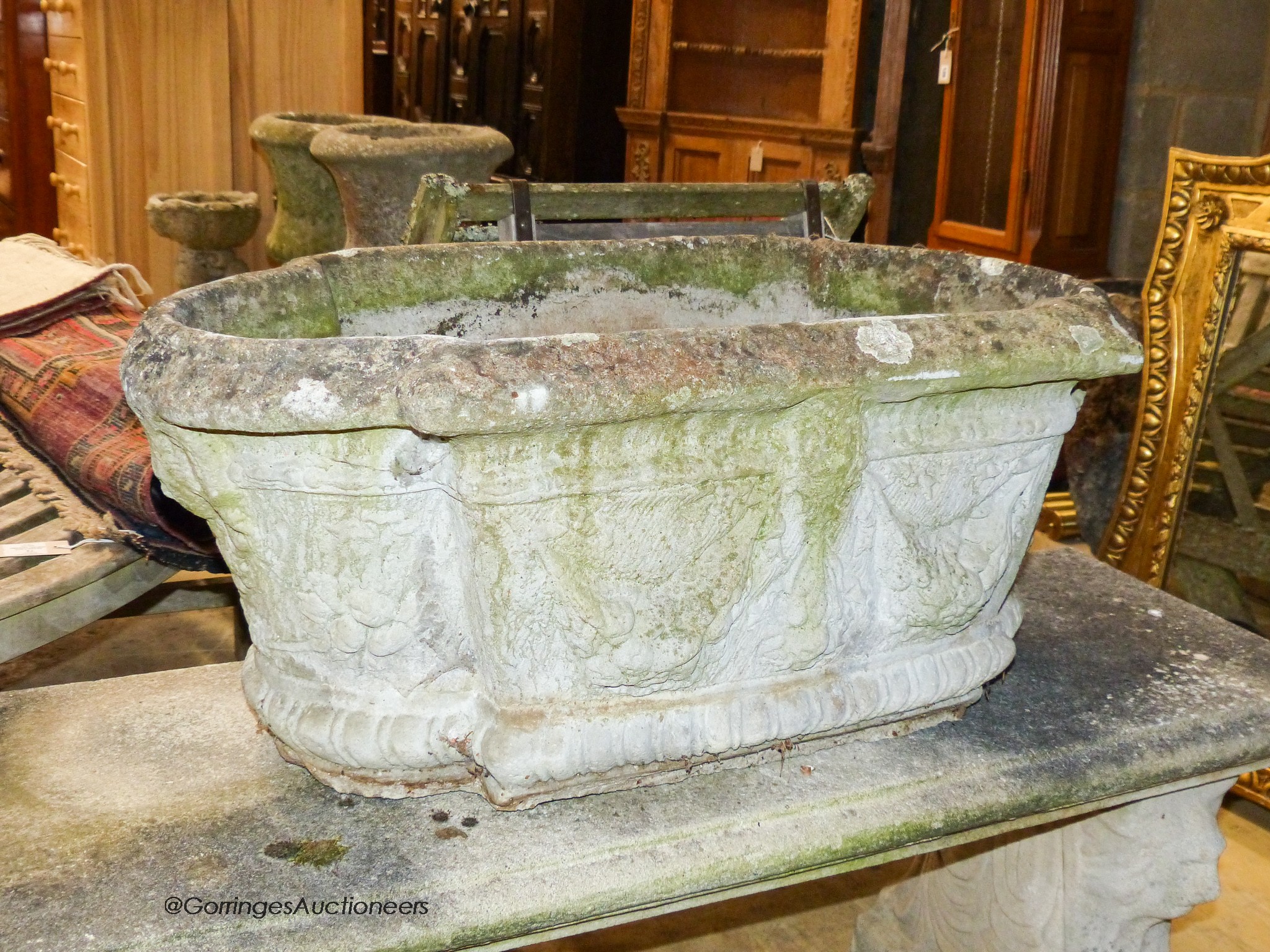 A pair of reconstituted stone shaped oval planters with swag decoration, width 80cm, height 42cm